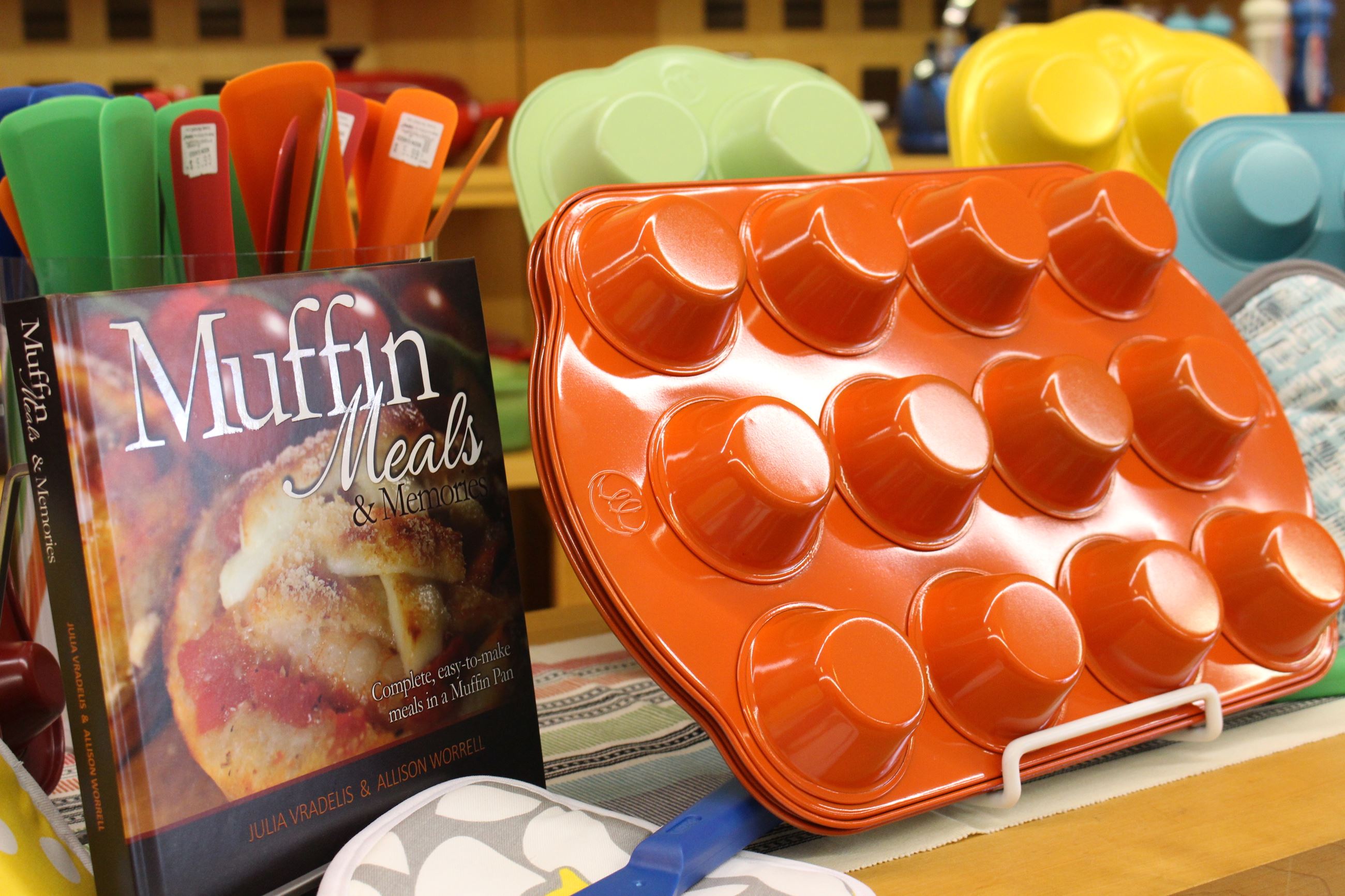 Orange muffin tin placed next to a muffin cookbook